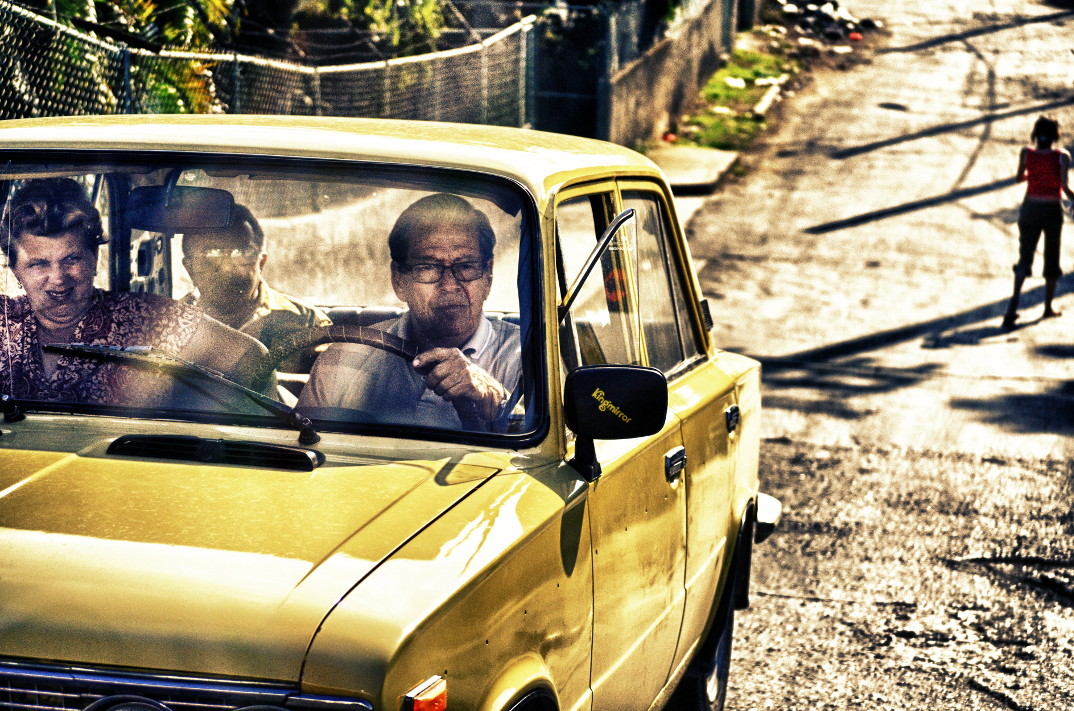 image of people travelling in a yellow car