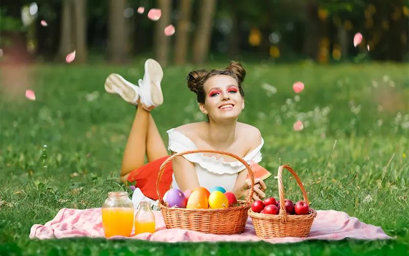 Spring photo overlay example with woman on picnic blanket and floating flower petals