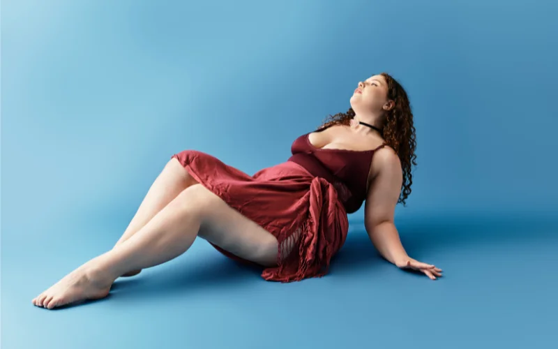 Plus size model lying on back with crossed legs in an elegant boudoir pose