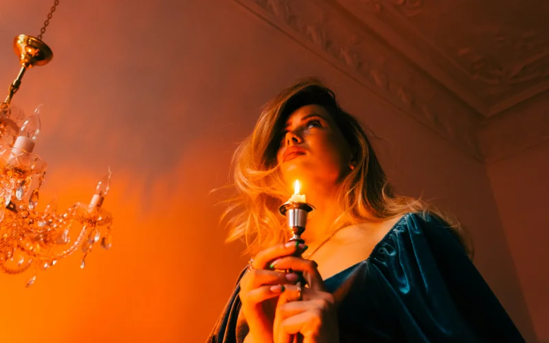 Romantic boudoir portrait featuring candles and warm ambient lighting
