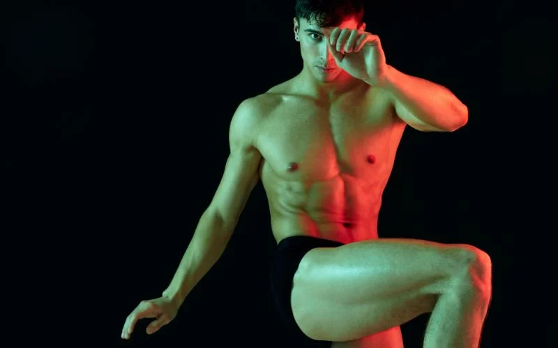 Dynamic male nude photography pose capturing movement and athletic energy