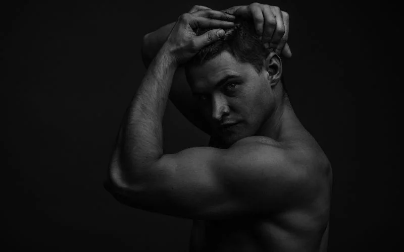 Black and white male nude portrait with dramatic contrast and composition