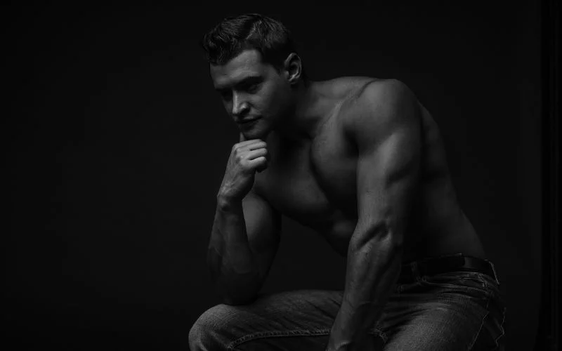 Male nude model bending forward in a dramatic fine art pose
