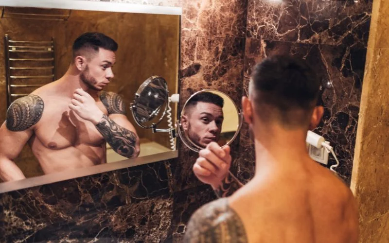 Creative male nude portrait using reflections for artistic visual composition
