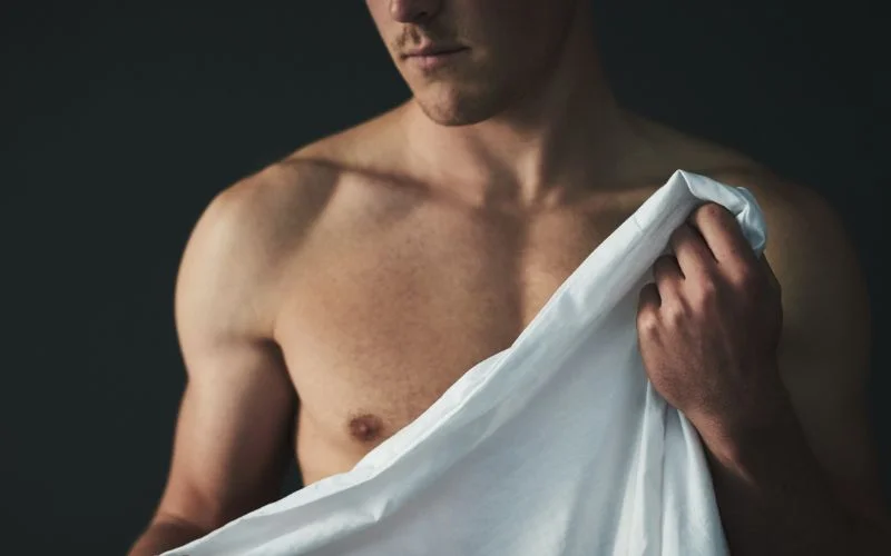 Male nude photography using bed sheets creatively for artistic composition