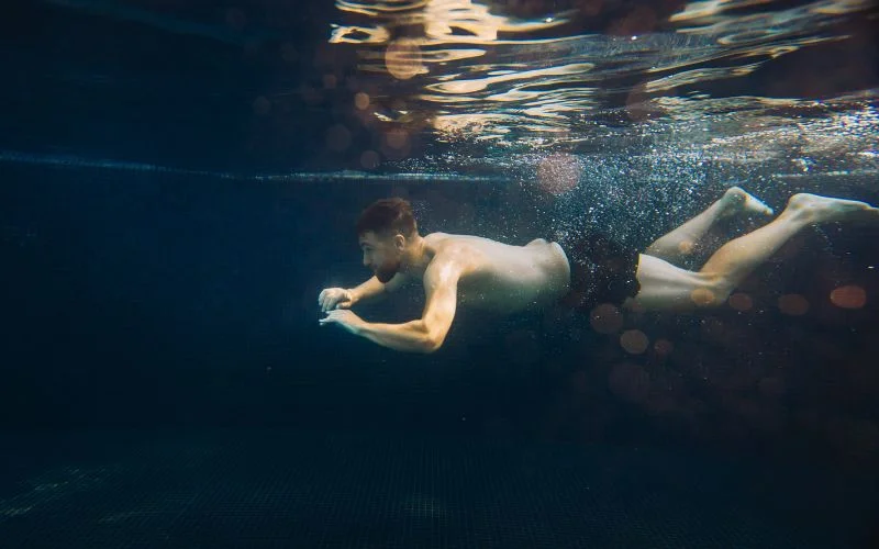 Underwater male nude photography with flowing movement and artistic lighting