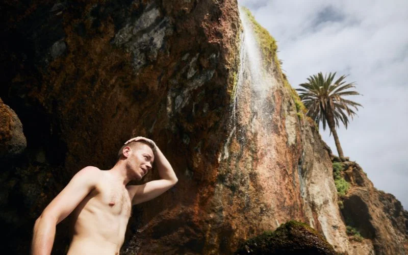 Classic male nude pose using hands creatively for artistic body framing