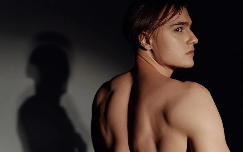 Shadow-focused men boudoir poses using contrast and light patterns for artistic portraits