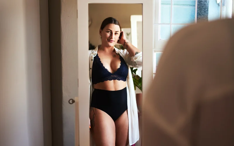 Model posing in front of a mirror, capturing both reflection and profile in one frame