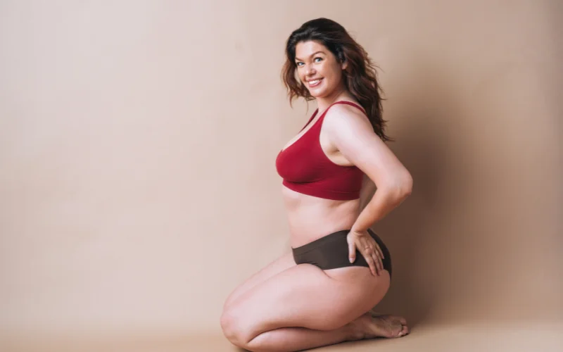 Graceful kneeling pose on a soft surface, spine curved for an elegant line