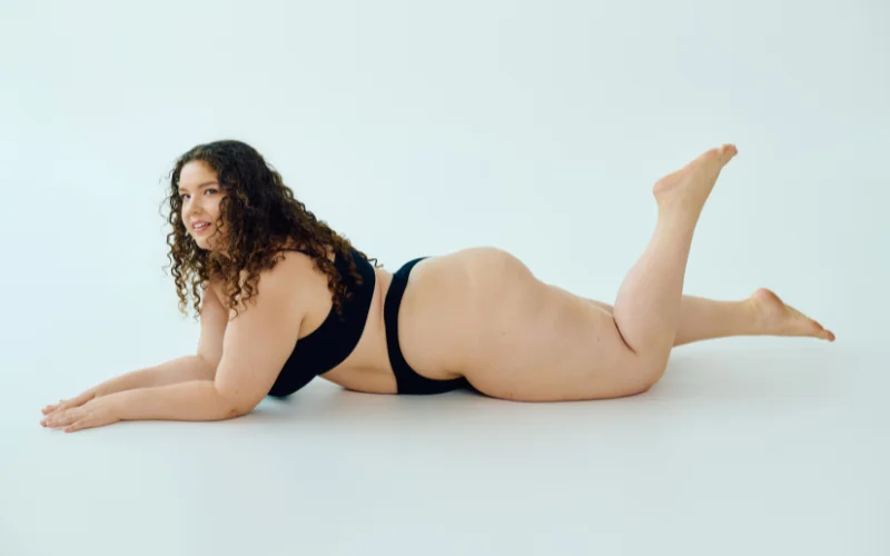 Candid, unposed moment captured mid-movement during a plus size nude photo shoot