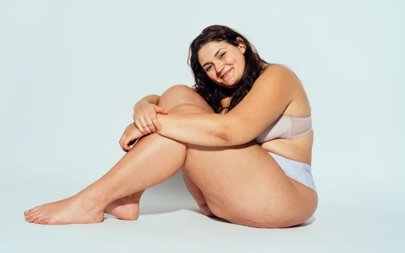 Relaxed seated pose on a plush chair, natural and unposed body language