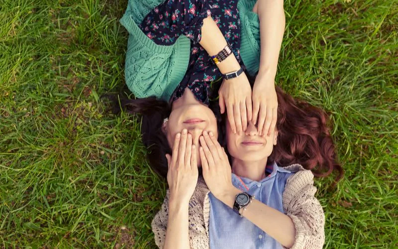 Best friend poses for 2 with both friends standing close, eyes closed, smiling softly