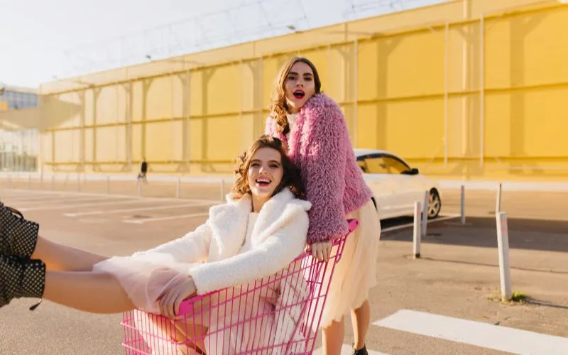 Two best friends laughing together during a piggyback ride in a candid outdoor pose
