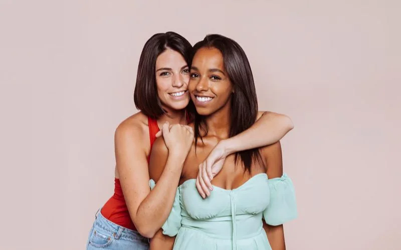 One friend resting her head gently on the other's shoulder