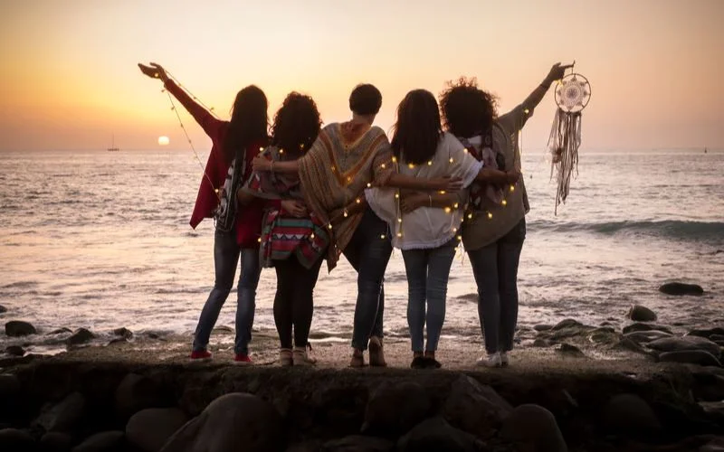 group of friends holding glowing fairy lights together in the evening