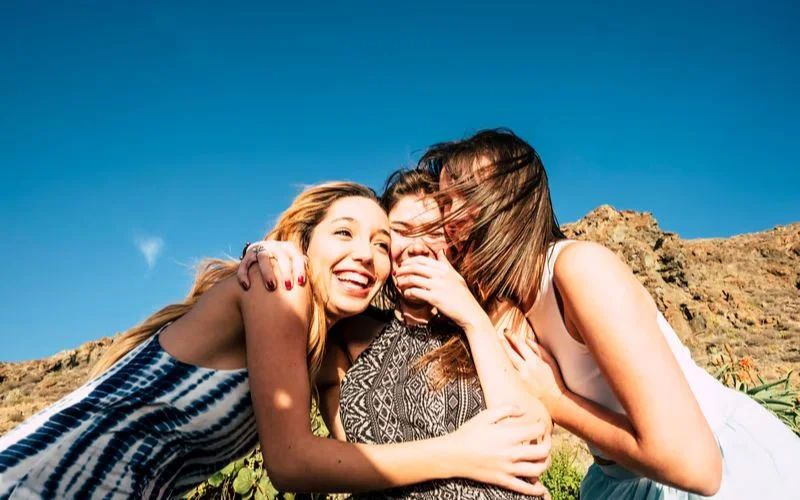 group of friends laughing while photobombing each other's shot