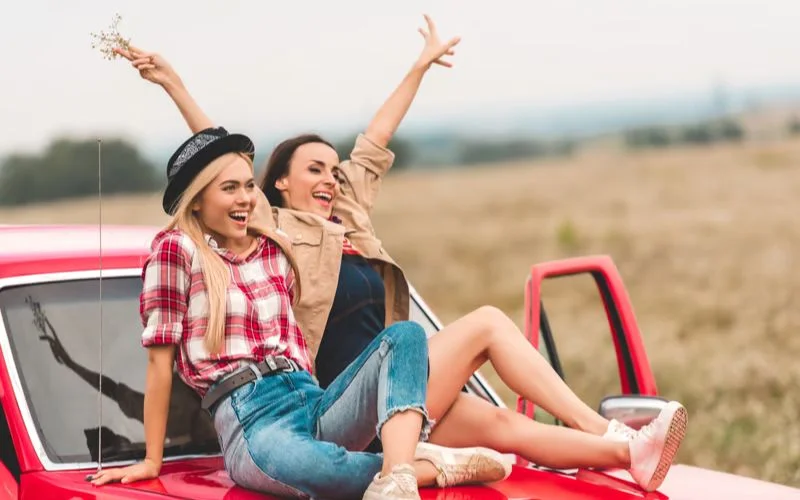 Best friends posing together on a road trip for a fun and adventurous photoshoot idea