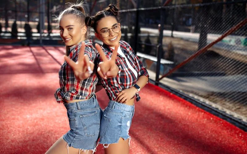 Best friends in matching twin outfits posing together for a coordinated photoshoot