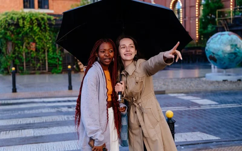 Two best friends sharing an umbrella in a charming and cozy bestie photo pose