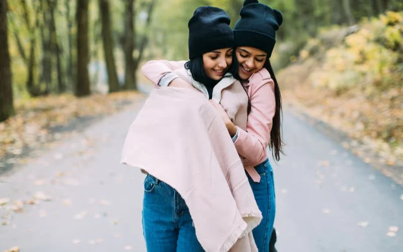 Two best friends wrapped together in a cozy blanket for a warm and candid photo