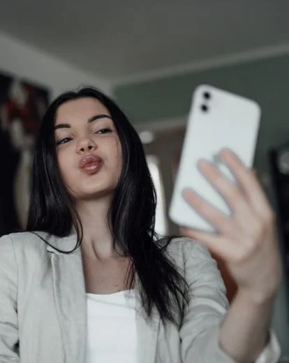 Close-up selfie of a person making a playful pout while looking directly at the camera.