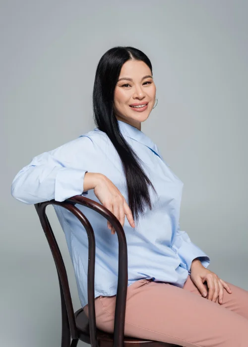 Female professional in a sitting down pose for a polished business portrait.
