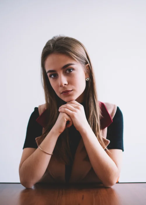 Corporate headshot with a hands on table pose, conveying confidence and professionalism.