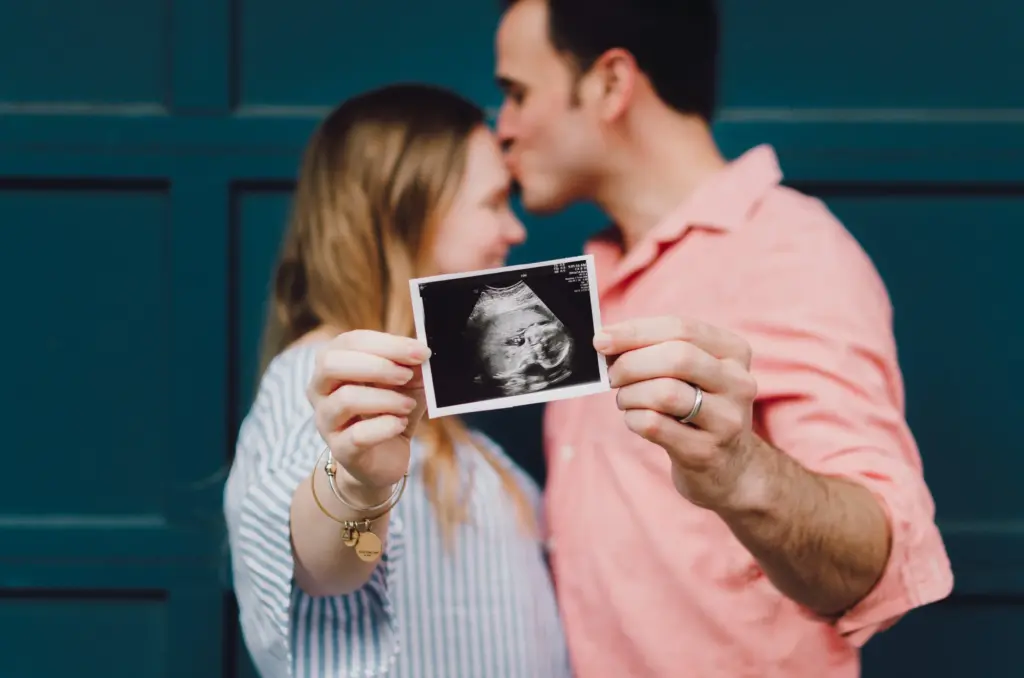 women and man holding sonogram