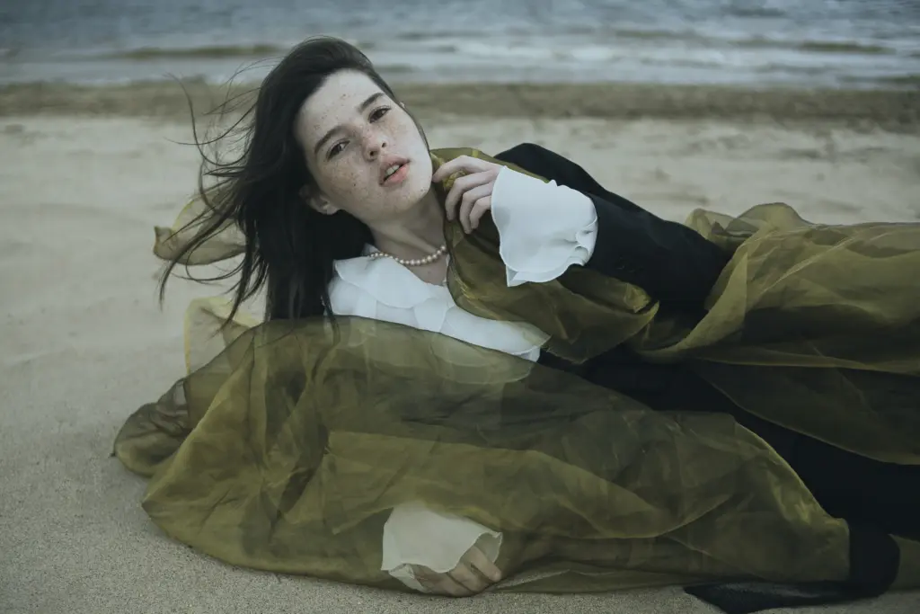 a model laying on sand for a shoot