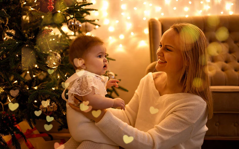 Christmas bokeh light overlay applied to photo of mother and baby by Christmas tree