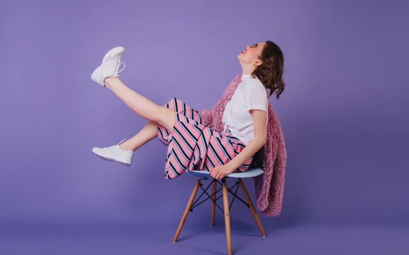 Bold and funky sitting pose with expressive posture and confident attitude