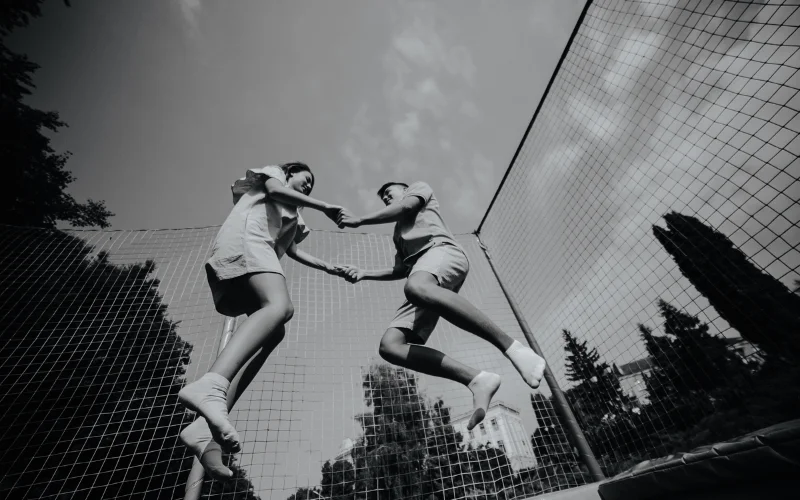candid photo poses - couple jumping on a trampoline candid picture poses