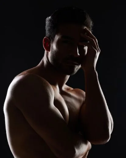Dramatic silhouette men boudoir portrait with moody lighting and shadows