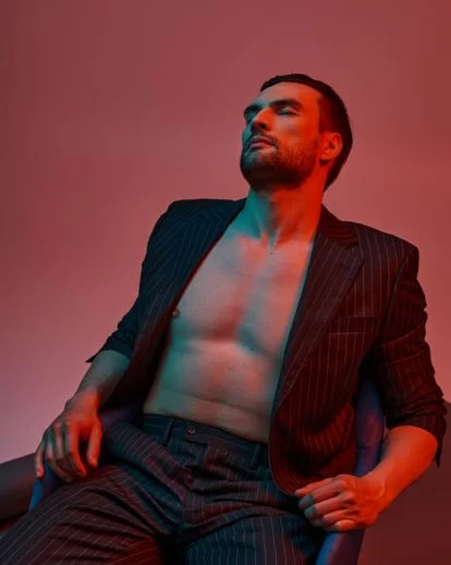 Stylish men boudoir pose featuring layered outfits and confident body language