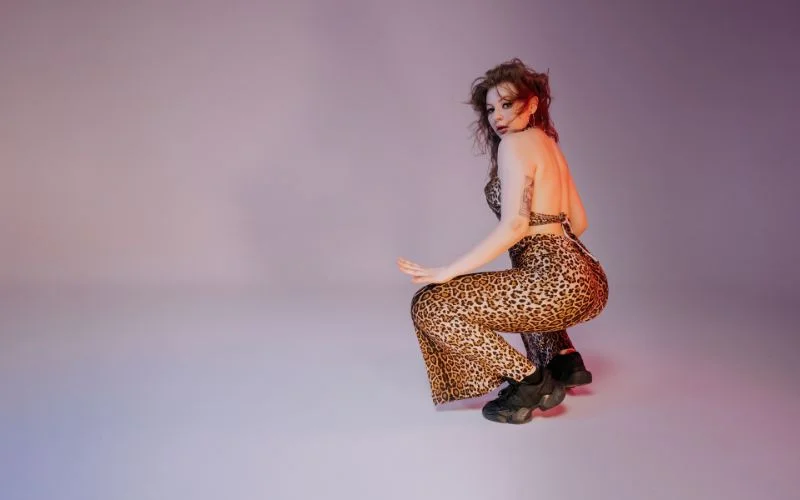 Dynamic squat pose with playful leg movement and energetic composition