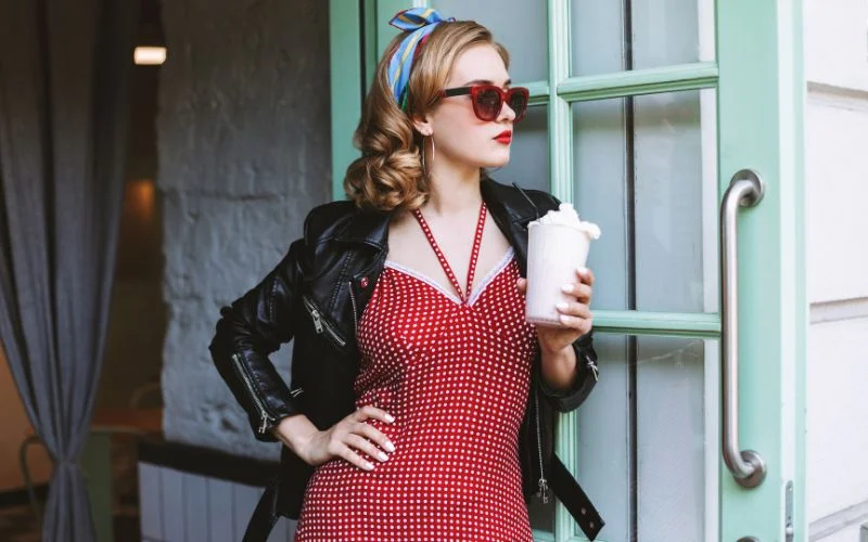 woman arching her back in a classic bombshell pin up pose inspired by old Hollywood