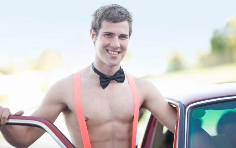 man in bow tie and suspenders channeling old Hollywood charm in a classic male pin up pose