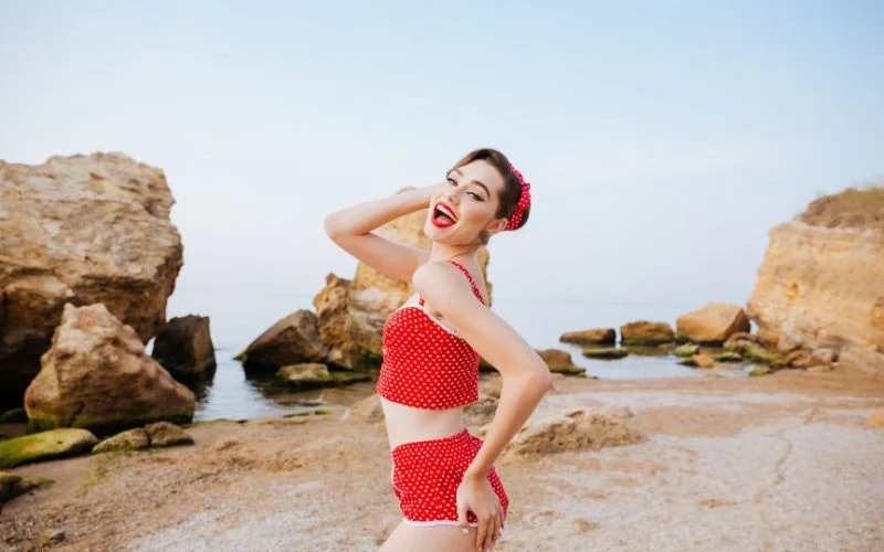 pin up model in a retro swimsuit standing confidently on a sunny beach
