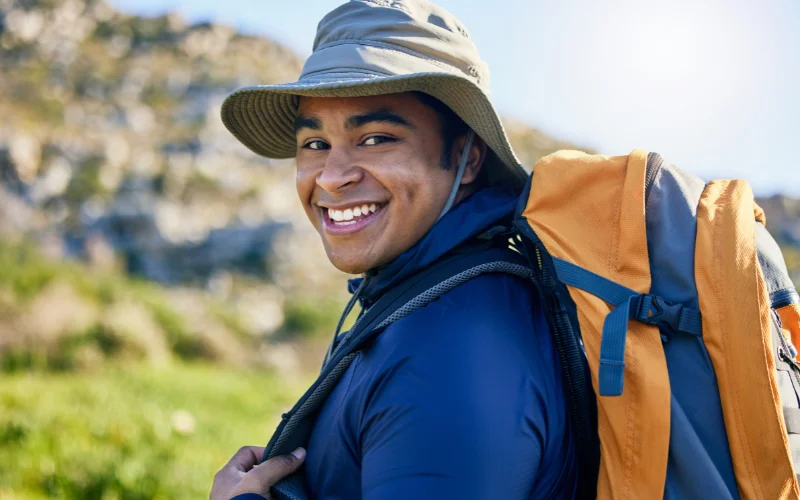Outdoor portrait of a hiker looking over their shoulder while standing on a scenic trail.