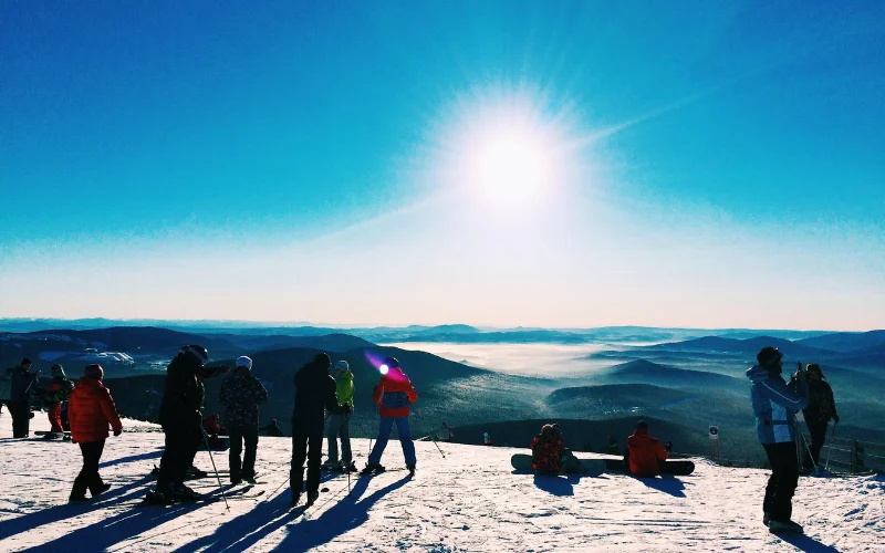 Hiker admiring panoramic mountain views from a summit overlook during a hiking adventure.