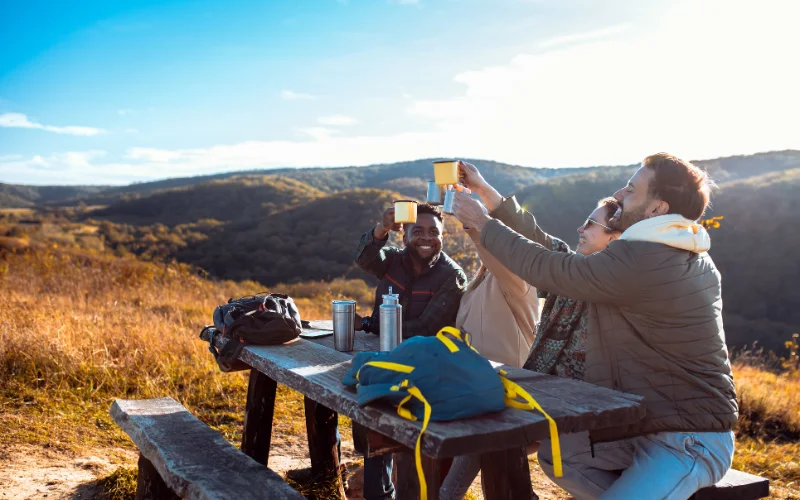 Hikers taking a break and enjoying a drink while surrounded by beautiful natural scenery on the trail.