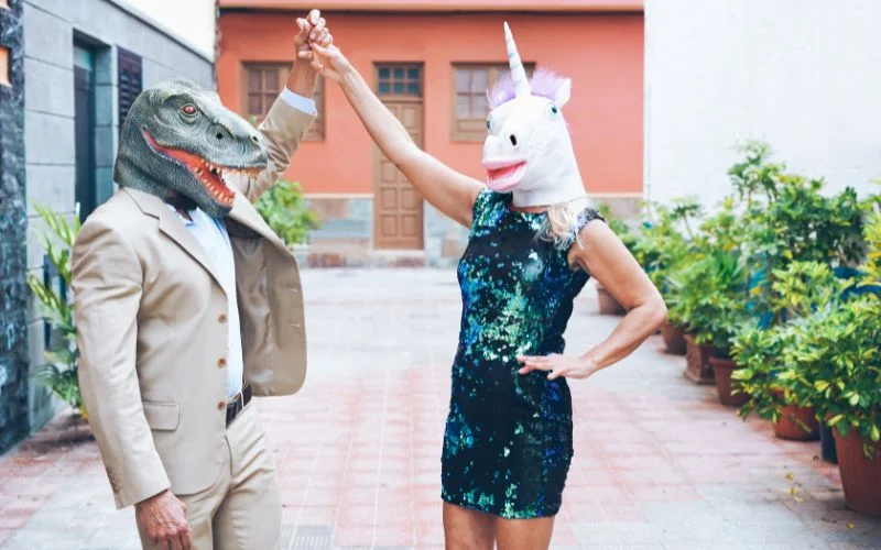 Funny prom picture pose with friends wearing dinosaur and unicorn masks