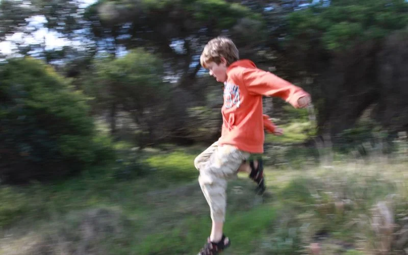 Boy captured mid-run at 1/500 sec shutter speed, one of several shutter speed photography examples showing frozen motion