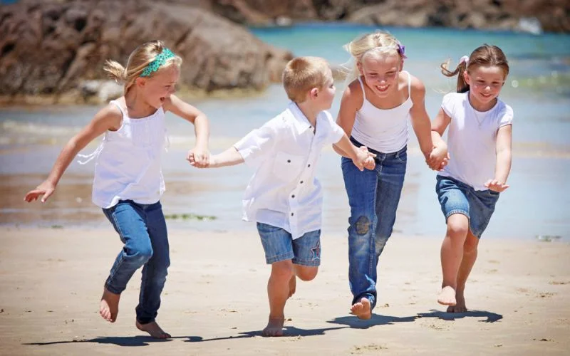 Family of four running together on the beach, frozen sharply at 1/1250 sec shutter speed