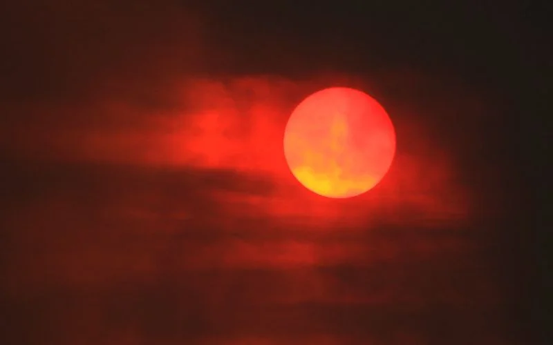 Deep red sun at sunset photographed at 1/2000 sec with a long lens to prevent camera shake