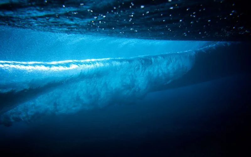 Underwater wave curling with crisp detail, shot at 1/8000 sec to freeze the water's motion