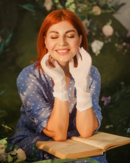 Woman resting her chin on her hands in a soft outdoor garden setting