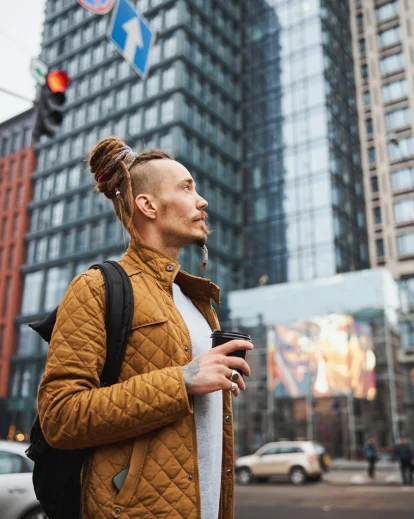 Woman walking through a city street wearing a backpack, part of a 30th birthday photoshoot for him