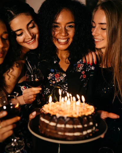 Three women smiling closely together, part of a cozy 30th birthday photoshoot